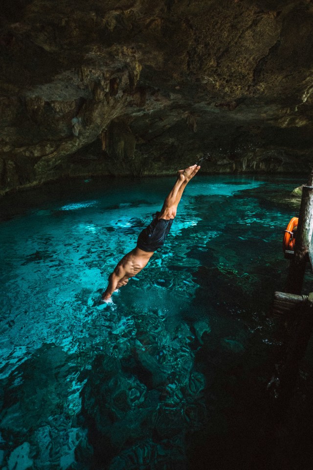 Man diving into a cenote at the SOL Retreat